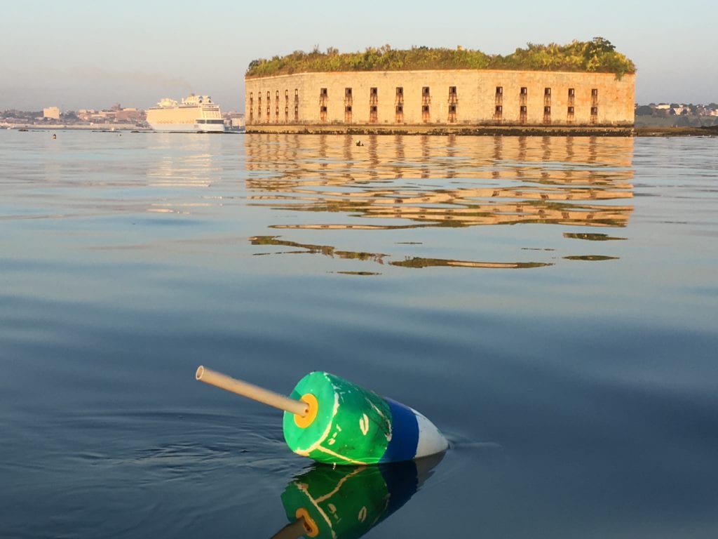 Photo of a lobster buoy and Fort Gorges in Casco Bay