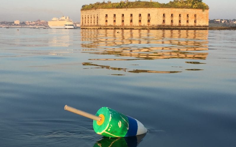 Photo of a lobster buoy and Fort Gorges in Casco Bay