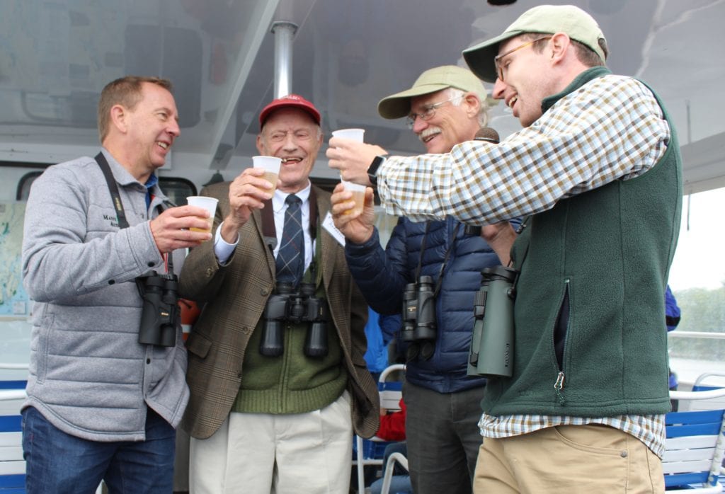 Maine Audubon Executive Director Andrew Beahm, former Executive Directors Dick Anderson and Bill Ginn, and Staff Naturalist Doug Hitchcox cheers during the 50th annual Bald Eagles of Merrymeeting Bay boat trip