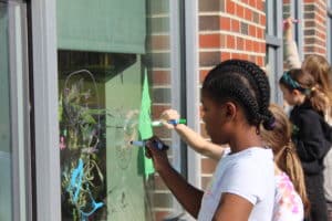 Yarmouth Elementary School students decorate windows with bird-safe designs