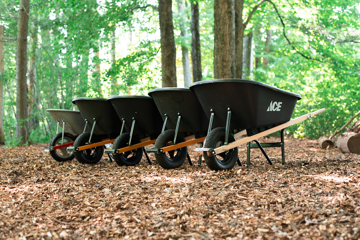 Wheelbarrows on mulch in a wooded area